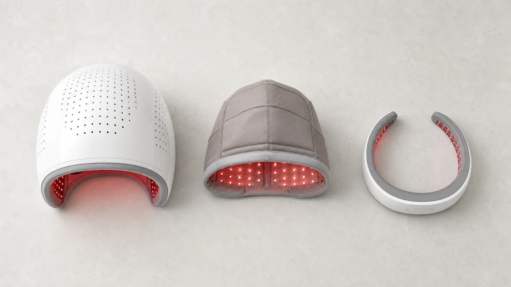 Three unbranded laser hair-growth devices: a rigid helmet, a soft cap and a handheld laser band